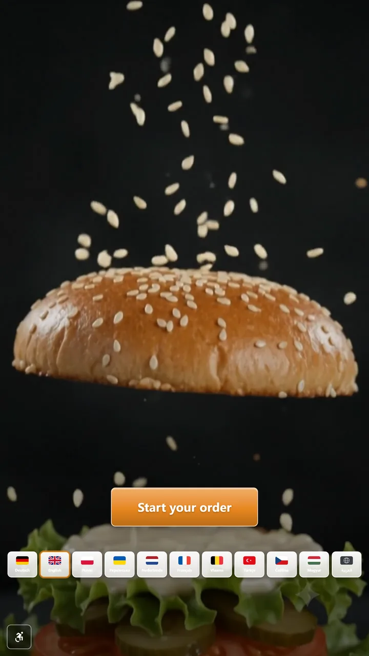 The kiosk attract screen: a sesame bun in mid-air on black, the button Start your order, and a row of eleven language flags.